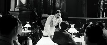 Movie still from “Adam Resurrected” (2008), directed by Paul Schrader – A man standing in front of two other men; Medium shot, Over the shoulder angle