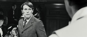 Movie still from “Adam Resurrected” (2008), directed by Paul Schrader – A black and white photo of a man in a suit and tie; Close Up shot, Over the shoulder angle