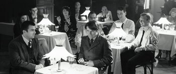 Movie still from “Adam Resurrected” (2008), directed by Paul Schrader – A group of people sitting at a dinner table; Medium shot, Over the shoulder angle