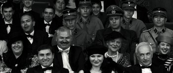 Movie still from “Adam Resurrected” (2008), directed by Paul Schrader – A black and white photo of a group of people in formal wear; Close Up shot, Over the shoulder angle
