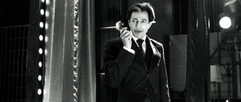 Movie still from “Adam Resurrected” (2008), directed by Paul Schrader – A black and white photo of a man talking on a cell phone; Medium shot, Low angle