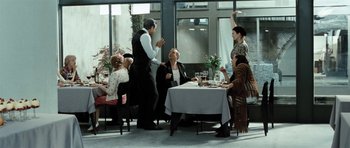Movie still from “Adam Resurrected” (2008), directed by Paul Schrader – A group of people sitting at a table with food; Wide shot, Over the shoulder angle