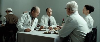 Movie still from “Adam Resurrected” (2008), directed by Paul Schrader – A group of men sitting at a table with food; Medium shot, Over the shoulder angle