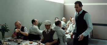 Movie still from “Adam Resurrected” (2008), directed by Paul Schrader – A group of men sitting around a table eating food; Wide shot, Over the shoulder angle