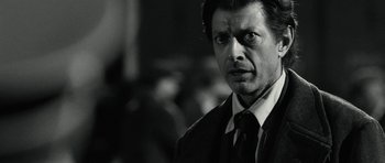 Movie still from “Adam Resurrected” (2008), directed by Paul Schrader – Black and white photograph of a man in a suit and tie; Close Up shot, Over the shoulder angle