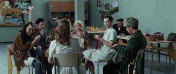 Movie still from “Adam Resurrected” (2008), directed by Paul Schrader – A group of people sitting in a room; Medium shot, Over the shoulder angle