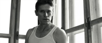 Movie still from “Adam Resurrected” (2008), directed by Paul Schrader – Black and white photograph of a man in a tank top; Close Up shot, Low angle