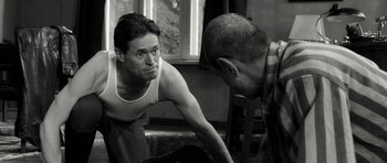 Movie still from “Adam Resurrected” (2008), directed by Paul Schrader – A man in a white shirt and a man in a plaid shirt; Medium shot, Over the shoulder angle