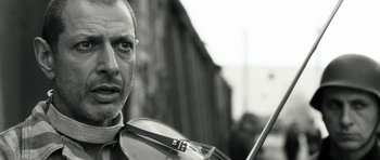 Movie still from “Adam Resurrected” (2008), directed by Paul Schrader – A person holding a violin; Close Up shot, Low angle