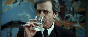 Movie still from “Adam Resurrected” (2008), directed by Paul Schrader – An older man drinking a glass of water; Close Up shot, Over the shoulder angle