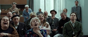 Movie still from “Adam Resurrected” (2008), directed by Paul Schrader – A group of people sitting in front of a window; Wide shot, Low angle