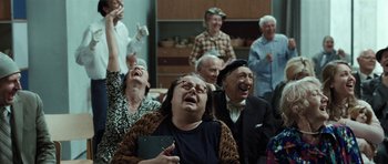 Movie still from “Adam Resurrected” (2008), directed by Paul Schrader – A group of old people laughing and singing together; Medium shot, High angle