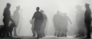 Movie still from “Adam Resurrected” (2008), directed by Paul Schrader – A group of people walking down a street in the fog; Extreme Wide shot, High angle