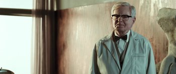 Movie still from “Adam Resurrected” (2008), directed by Paul Schrader – An older man wearing a white coat and a bow tie; Close Up shot, Low angle