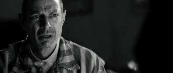 Movie still from “Adam Resurrected” (2008), directed by Paul Schrader – A black and white photo of a man in a striped shirt; Close Up shot, Over the shoulder angle