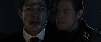 Movie still from “Adam Resurrected” (2008), directed by Paul Schrader – Two men in a dark room looking at the camera; Close Up shot, Overhead angle