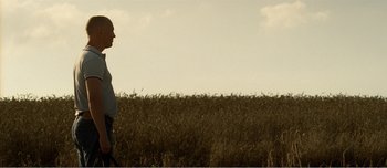 Movie still from “Adam's Apples” (2005), directed by Anders Thomas Jensen – A man standing in the middle of an open field; Wide shot, Low angle