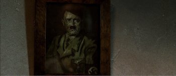 Movie still from “Adam's Apples” (2005), directed by Anders Thomas Jensen – A painting of adolf hitler is displayed on a wall; Close Up shot, High angle