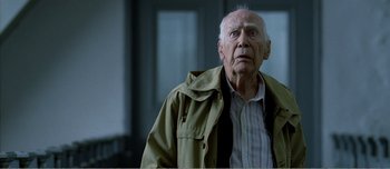 Movie still from “Adam's Apples” (2005), directed by Anders Thomas Jensen – An older man in a jacket looking at the camera; Close Up shot, Low angle