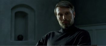 Movie still from “Adam's Apples” (2005), directed by Anders Thomas Jensen – A person with a beard wearing a black shirt; Close Up shot, Over the shoulder angle