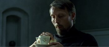 Movie still from “Adam's Apples” (2005), directed by Anders Thomas Jensen – A man with a beard is drinking from a coffee cup; Close Up shot, Low angle
