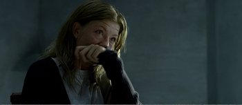 Movie still from “Adam's Apples” (2005), directed by Anders Thomas Jensen – A woman with long blonde hair is holding her hand to her face; Close Up shot, Over the shoulder angle
