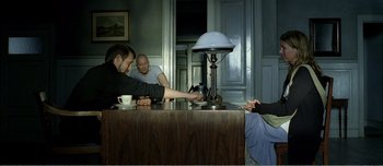 Movie still from “Adam's Apples” (2005), directed by Anders Thomas Jensen – A group of people sitting around a table; Medium shot, High angle