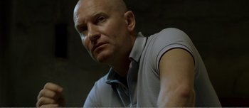 Movie still from “Adam's Apples” (2005), directed by Anders Thomas Jensen – A man with bald head looking to his left; Close Up shot, Low angle