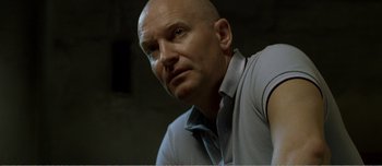 Movie still from “Adam's Apples” (2005), directed by Anders Thomas Jensen – A man with a shaved head is looking into the distance; Close Up shot, Low angle