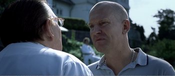 Movie still from “Adam's Apples” (2005), directed by Anders Thomas Jensen – A man with a bald head talking to another man; Close Up shot, Over the shoulder angle