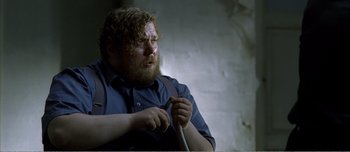 Movie still from “Adam's Apples” (2005), directed by Anders Thomas Jensen – A man with a long beard holding a stick; Close Up shot, High angle