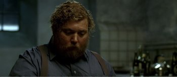 Movie still from “Adam's Apples” (2005), directed by Anders Thomas Jensen – A person with a beard wearing a blue shirt; Close Up shot, Over the shoulder angle