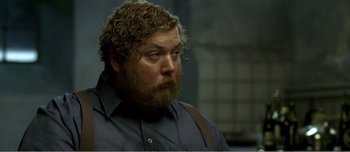 Movie still from “Adam's Apples” (2005), directed by Anders Thomas Jensen – A person with a beard wearing a blue shirt; Close Up shot, Over the shoulder angle