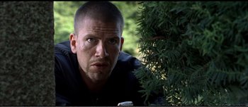 Movie still from “Adam's Apples” (2005), directed by Anders Thomas Jensen – A person near a tree; Close Up shot, Low angle