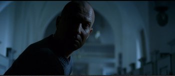 Movie still from “Adam's Apples” (2005), directed by Anders Thomas Jensen – A man with a bald head is looking at the camera; Close Up shot, Low angle