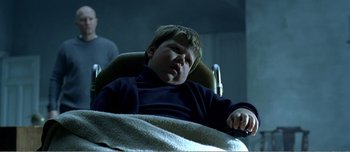 Movie still from “Adam's Apples” (2005), directed by Anders Thomas Jensen – A young boy laying in a chair with a blanket; Medium shot, High angle