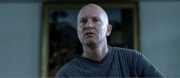 Movie still from “Adam's Apples” (2005), directed by Anders Thomas Jensen – A man with bald head looking to his left; Close Up shot, Low angle