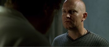 Movie still from “Adam's Apples” (2005), directed by Anders Thomas Jensen – A man with a bald head looking at another man with a bald head; Close Up shot, Over the shoulder angle
