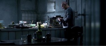 Movie still from “Adam's Apples” (2005), directed by Anders Thomas Jensen – A man standing in front of an oven in a kitchen; Medium shot, Low angle