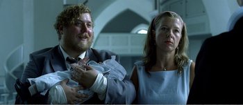 Movie still from “Adam's Apples” (2005), directed by Anders Thomas Jensen – A man and a woman standing next to each other; Close Up shot, Low angle