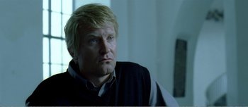 Movie still from “Adam's Apples” (2005), directed by Anders Thomas Jensen – A person wearing a shirt and a vest; Close Up shot, Over the shoulder angle