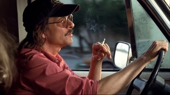 Movie still from “Adaptation.” (2002), directed by Spike Jonze – A man sitting in the drivers seat of a car while smoking a cigarette; Close Up shot, Low angle