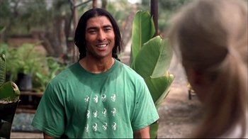 Movie still from “Adaptation.” (2002), directed by Spike Jonze – A man with long black hair wearing a green t - shirt; Medium shot, Over the shoulder angle