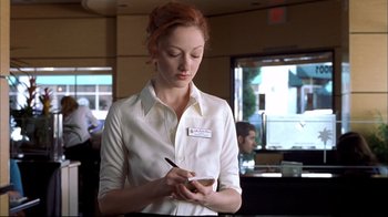 Movie still from “Adaptation.” (2002), directed by Spike Jonze – A woman in a white shirt is writing on a paper; Medium shot, Low angle