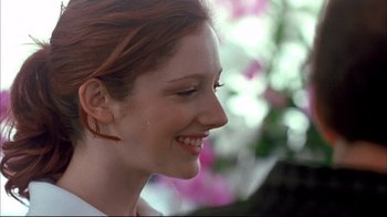 Movie still from “Adaptation.” (2002), directed by Spike Jonze – A person smiling with flowers in the background; Close Up shot, Over the shoulder angle