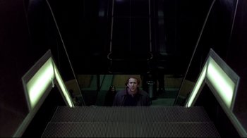 Movie still from “Adaptation.” (2002), directed by Spike Jonze – A man standing on top of an escalator at night; Wide shot, Low angle