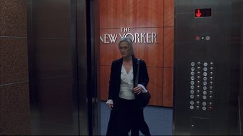 Movie still from “Adaptation.” (2002), directed by Spike Jonze – A woman standing in an elevator in front of the new yorker logo; Medium shot, Low angle