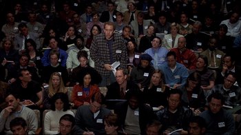Movie still from “Adaptation.” (2002), directed by Spike Jonze – A large group of people sitting in a room; Medium shot, High angle