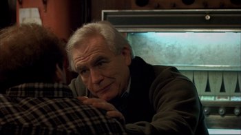 Movie still from “Adaptation.” (2002), directed by Spike Jonze – An older man sitting next to a younger man; Close Up shot, Over the shoulder angle