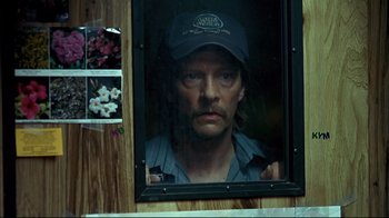 Movie still from “Adaptation.” (2002), directed by Spike Jonze – A person wearing a hat looking out a window; Close Up shot, Over the shoulder angle